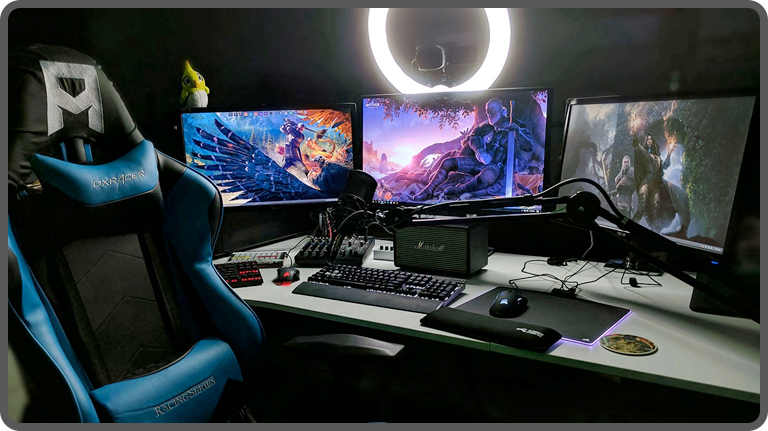 Professional online gaming streaming set up with three monitors and ring light